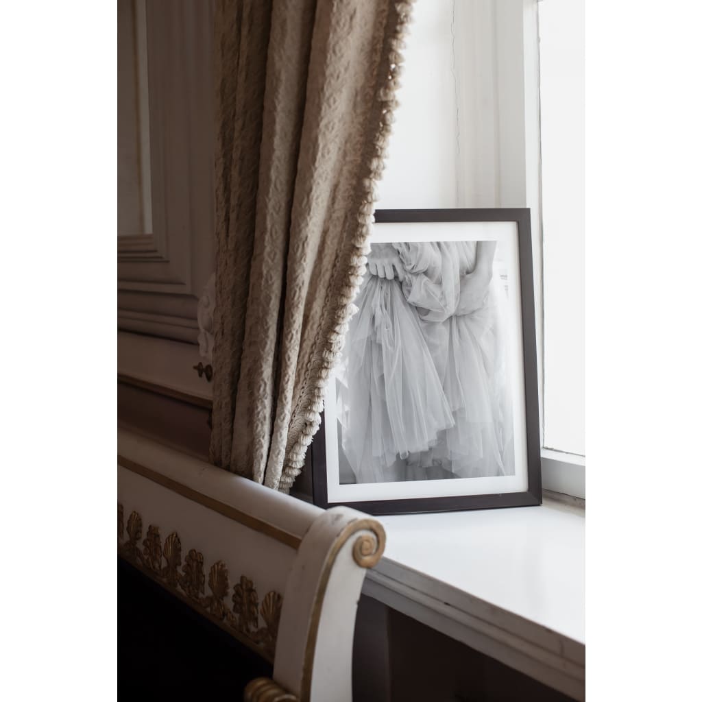 black and white fine art print in black frame, close up of hands holding up tulle skirt, softness, frame on window sill in French interior