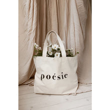 Load image into Gallery viewer, natural organic bag with the word poésie printed in large letters in middle, filled with cosmos flowers against pale blush linen fabric backdrop
